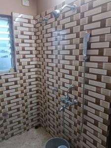 y baño con ducha en una pared de ladrillo. en Your Right Place en Guwahati