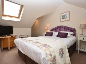 um quarto com uma cama grande e uma televisão em 2 Bed in Edinburgh 42778 em Roslin