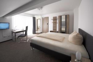 1 dormitorio con cama, escritorio y ordenador en Hotel New In Guesthouse, en Ingolstadt