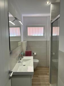 a bathroom with a sink and a toilet and a mirror at Vivienda vacacional “Punta de la arena” in Breña Baja