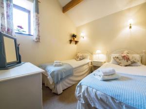 a bedroom with two beds and a tv in it at 2 Bed in Ashford in the Water PK502 in Great Longstone