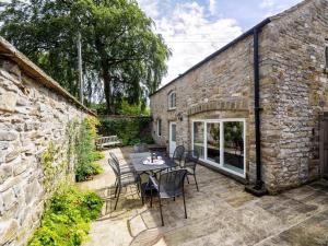 a patio with a table and chairs in front of a stone building at 3 Bed in Eyam PK833 in Eyam