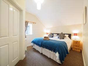 a bedroom with a bed with a blue blanket at 3 Bed in Eyam PK833 in Eyam