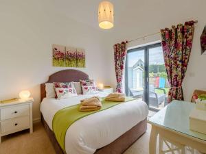 um quarto com uma cama, uma secretária e uma janela em 3 Bed in Westward Ho 46252 em Northam