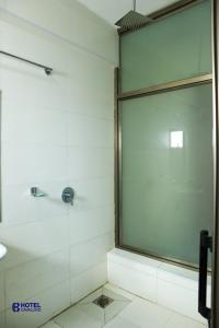 y baño con ducha y puerta de cristal. en Hotel Cavallino, en Kakamega