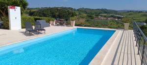 a swimming pool with chairs and a view of a hill at Casa Ceedina Bed And Breakfast & Beauty in Batalha