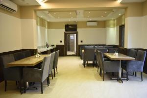 HOTEL SUPREME (VASCO) في Vasco Da Gama: غرفة طعام مع طاولات وكراسي خشبية