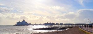 a pier with buildings on the beach and the ocean at Eastbourne Beautiful Seafront house in Eastbourne