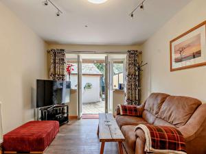 ein Wohnzimmer mit einem Sofa und einem TV in der Unterkunft 1 Bed in Ross-on-Wye 49910 in Walford