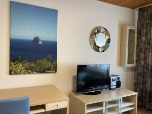 Zimmer mit einem TV und einem Tisch mit einem Spiegel in der Unterkunft Ferienwohnung Brenderweg in Koblenz