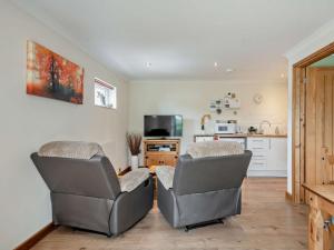 a living room with two chairs and a kitchen at 1 Bed in Brundall 46293 in Brundall