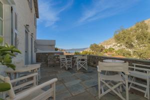 a patio with tables and chairs on a building at Nereids Guesthouse in Hydra