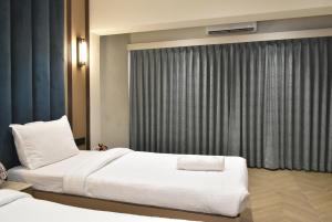HOTEL SUPREME (VASCO) في Vasco Da Gama: غرفة فندقية بسريرين ونافذة