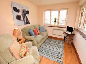 a living room with two couches and a cow painting on the wall at 1 bed property in Banbury Cotswolds CC012 in Shotteswell