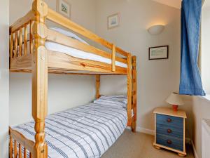 ein Schlafzimmer mit einem Etagenbett und einem blauen Vorhang in der Unterkunft 4 Bed in Bude 50591 in Bude