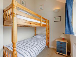 a bedroom with a bunk bed and a blue curtain at 4 Bed in Bude 50591 in Bude
