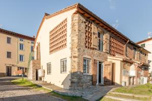 an old stone building in a street at La Capanna di Arturo Piano Terra in Capannori