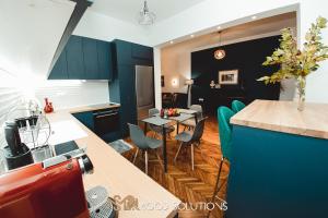 a kitchen with blue cabinets and a table with chairs at FirstLineSkg3 Moodsolutions Living in Thessaloniki