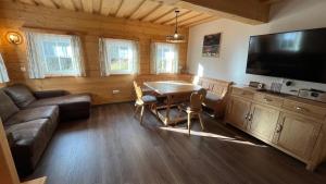 a living room with a couch and a table and a television at Ferienhaus Holzer in Mönichwald