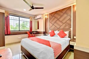 a bedroom with a bed and a desk and a window at OYO Sri Sai Comforts in Bangalore