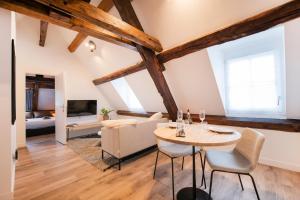 een woonkamer met een tafel en een bank bij Le Laurencin Sens - L Authentique in Sens