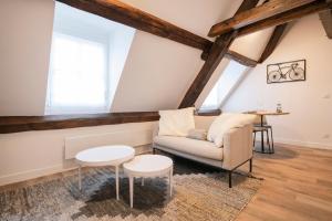 a living room with a couch and a table at Le Laurencin Sens - L Authentique in Sens