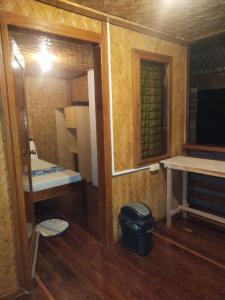 a small room with a bench and a table and a window at Ziah's Guest House in San Vicente