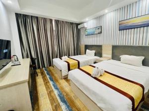 a hotel room with two beds and a television at Fusion Hotel in Sihanoukville