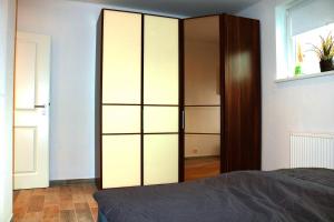 a bedroom with a large closet with glass doors at Ferienwohnungen Arp "2O" mit Garten und Parkplatz in Itzehoe