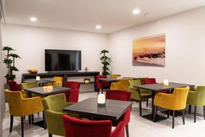 un restaurante con mesas y sillas y TV de pantalla plana en Motel-Résidence Ô Pied à Terre, en Montilliez