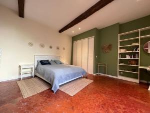 um quarto com uma cama e paredes verdes em Appartement spacieux et calme à Aix en Provence em Aix-en-Provence