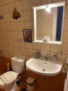 een badkamer met een wastafel, een toilet en een raam bij Kea Amazing View Maisonette in Ioulida
