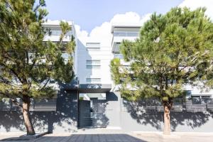 two trees in front of a white building at 3 Bed luxury apartment with pool in Glyfada in Athens