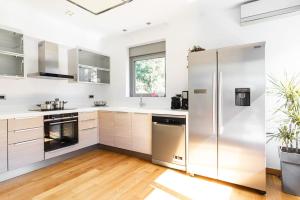 a kitchen with stainless steel appliances and wood floors at 3 Bed luxury apartment with pool in Glyfada in Athens