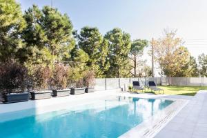 a swimming pool with two chairs next to a fence at 3 Bed luxury apartment with pool in Glyfada in Athens