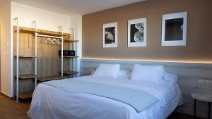 Un dormitorio con una cama grande con sábanas blancas. en La Hospedería - El Provencio, en El Provencio