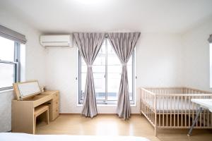 a bedroom with a crib and a large window at Shinokubo guest house in Tokyo