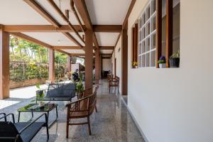 マランにあるRedDoorz Syariah near Batu Night Spectacularの屋内パティオ(椅子、テーブル、窓付)