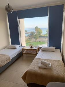 two beds in a room with a large window at PALLINIO COURT 402 Fig Tree Bay- Protaras Beach, IASONOS STR 7A in Protaras +81 photos