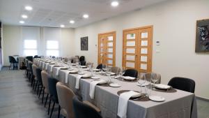 una habitación con una mesa larga con sillas y copas de vino en La Hospedería - El Provencio, en El Provencio