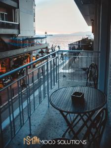 a table on a balcony with a view of the ocean at FirstLineSkg3 Moodsolutions Living in Thessaloniki