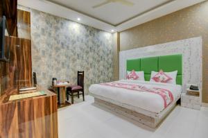 a bedroom with a bed with a green headboard at Hotel Smart Signature Delhi Airport in New Delhi