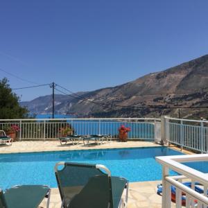 einen Pool mit Stühlen und Bergblick in der Unterkunft Villa Eros in Zóla