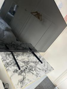 a glass table with a black and white marble top at Bright Master Bedroom Saturn in London