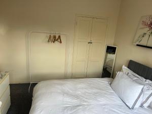 a bedroom with a white bed and a closet at Bright Master Bedroom Saturn in London