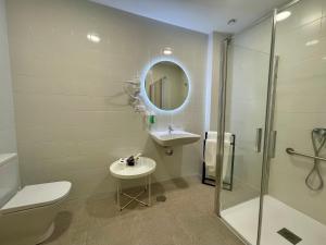 Un baño con inodoro, lavabo y ducha. en La Hospedería - El Provencio, en El Provencio