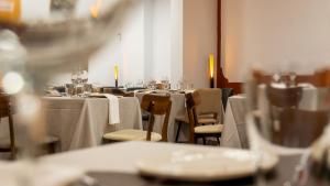 Un comedor con mesas y sillas con mantel blanco. en La Hospedería - El Provencio, en El Provencio