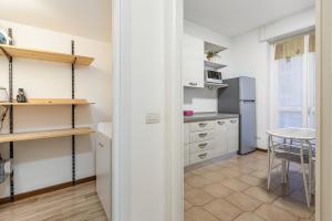 une cuisine avec des placards blancs et une table dans l'établissement [AFFORI CENTRO METRO] Appartamento con camera e cucina, à Milan