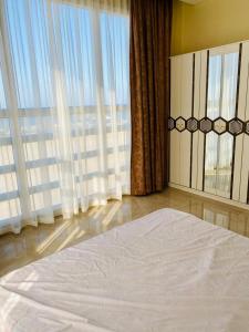 1 dormitorio con 1 cama grande y ventanas grandes en Al seeb beach appartements, en Seeb