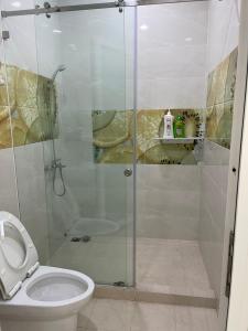 a bathroom with a glass shower with a toilet at Bếp Ông Tỏi Homestay in Ho Chi Minh City